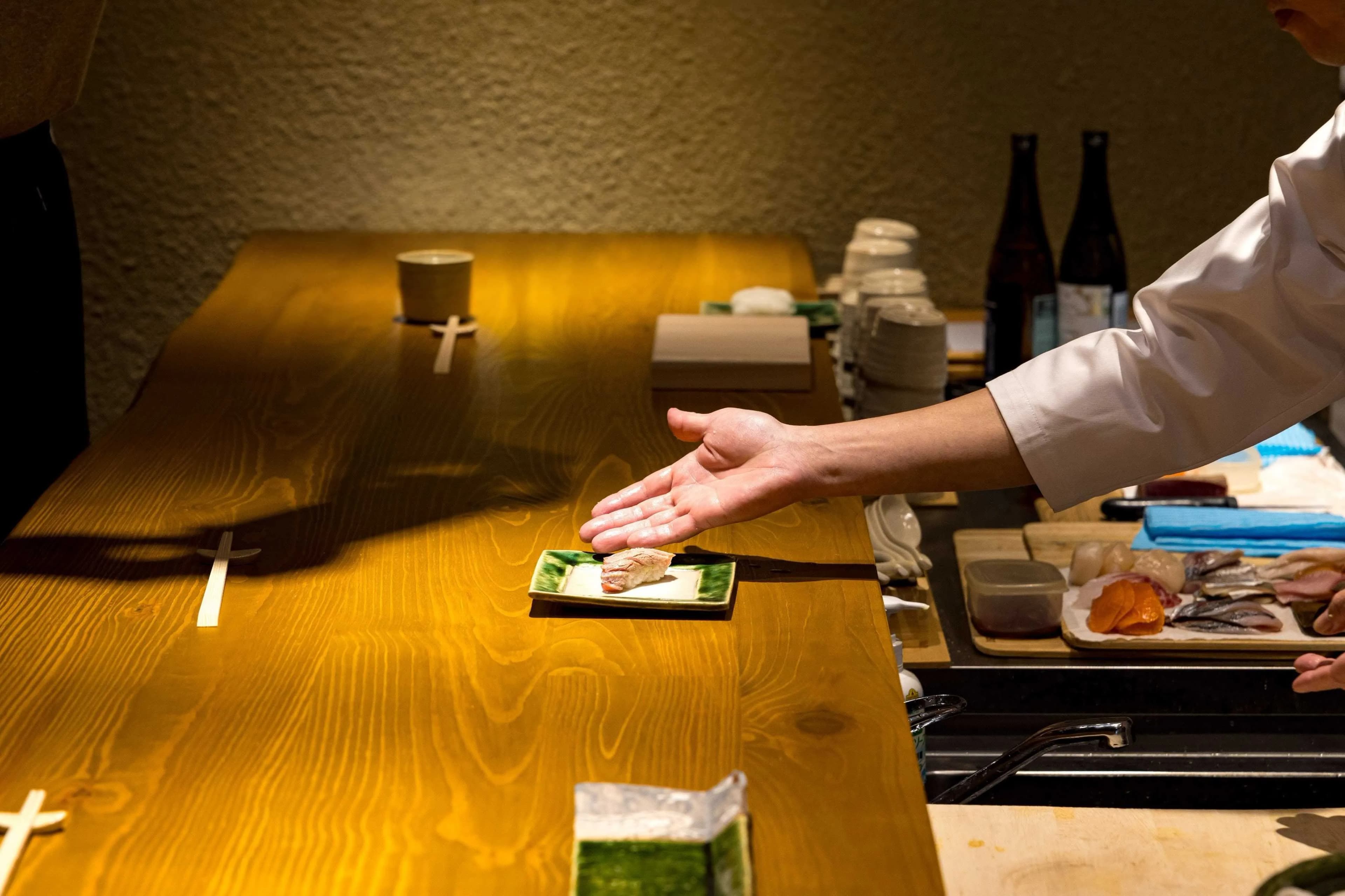 Chef presenting freshly made sushi to the guest